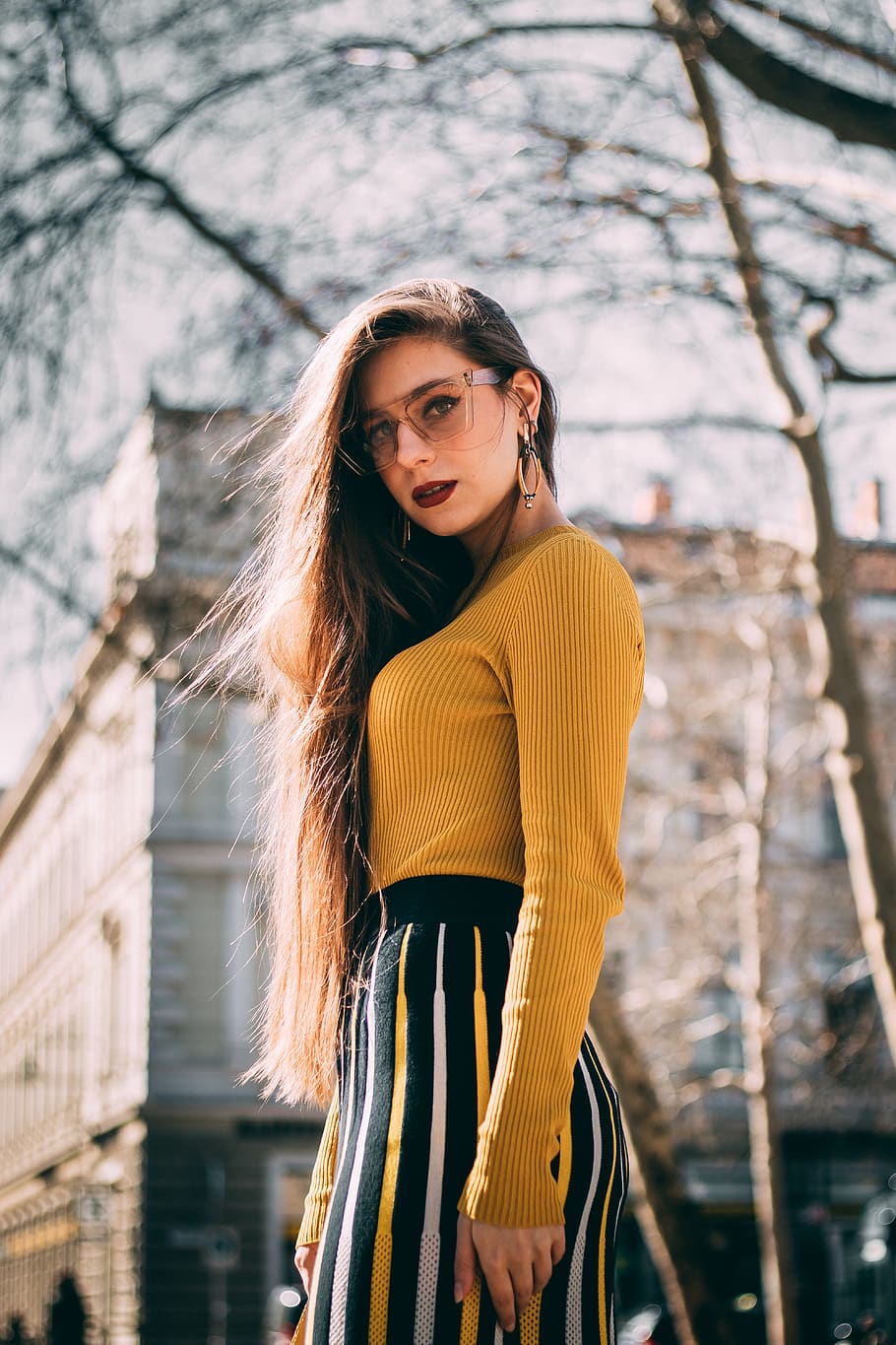 woman-in-yellow-long-sleeve-shirt-near-concrete-building-during-daytime.jpg