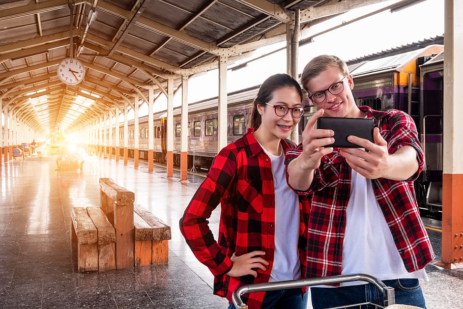 Man and Woman Taking Selfie Near Gray Train, cellphone, clock HD wallpaper
