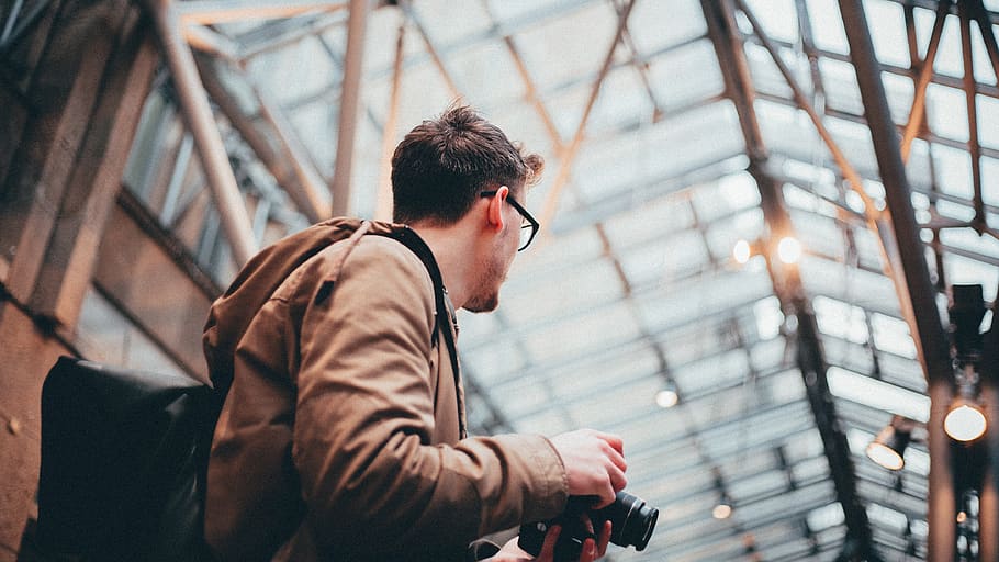 Man Standing While Holding Black Dslr Camera, blurred background HD wallpaper