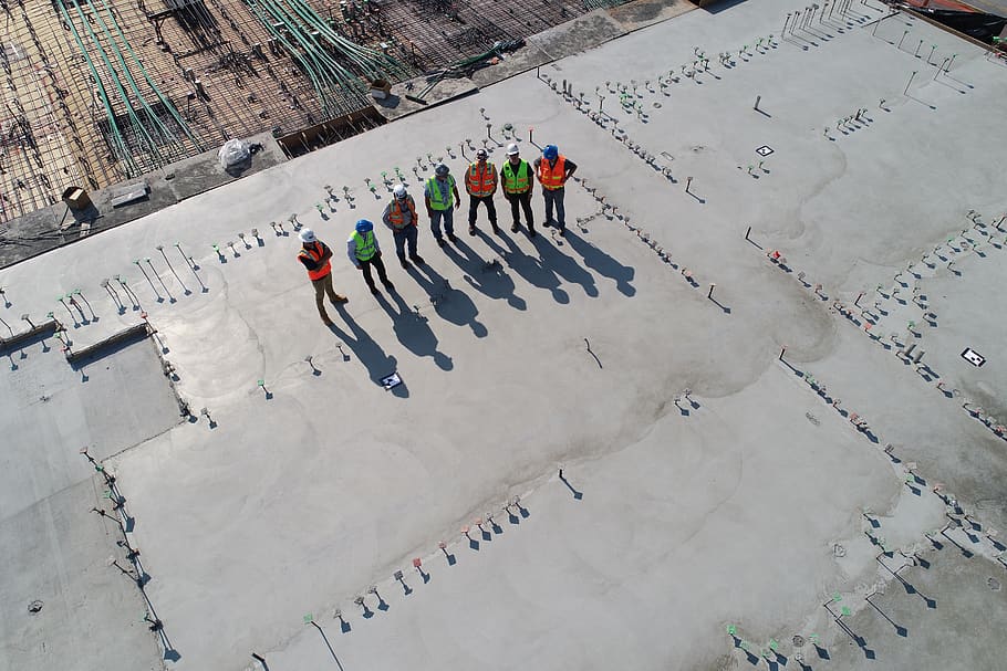 seven construction workers standing on white field, person, human