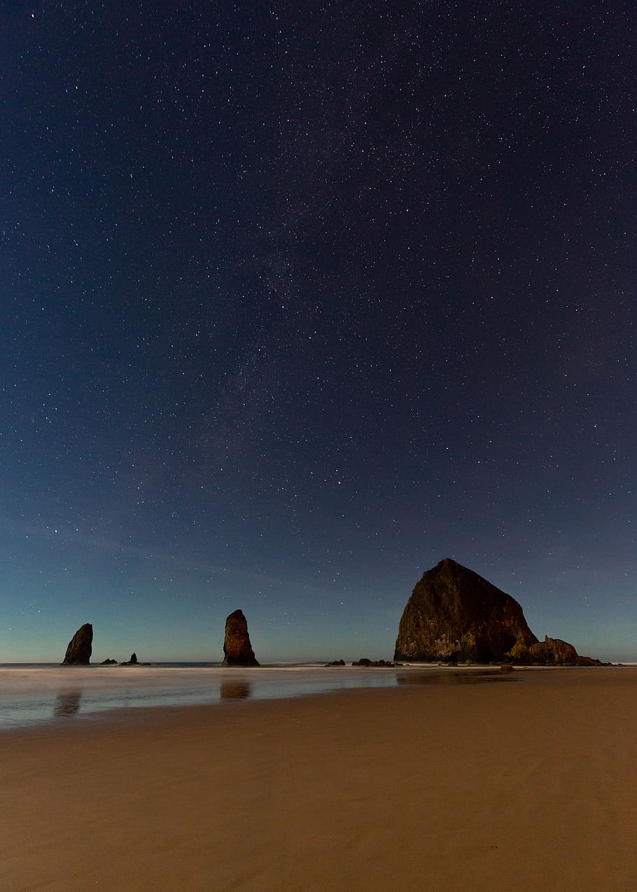 rock formation near shore under starry sky, nature, outdoors