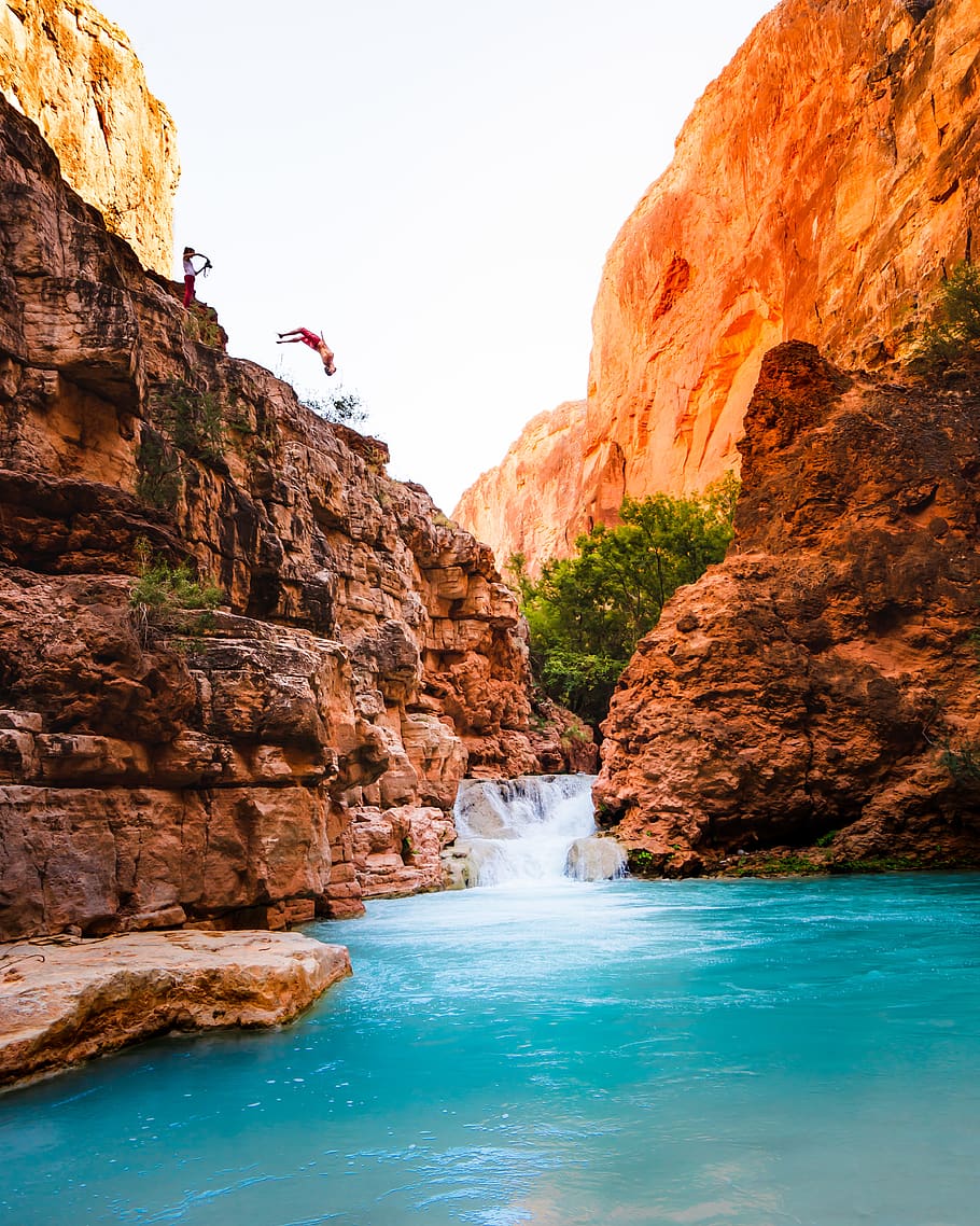 man jumping into river, water, rock, rock - object, rock formation HD wallpaper