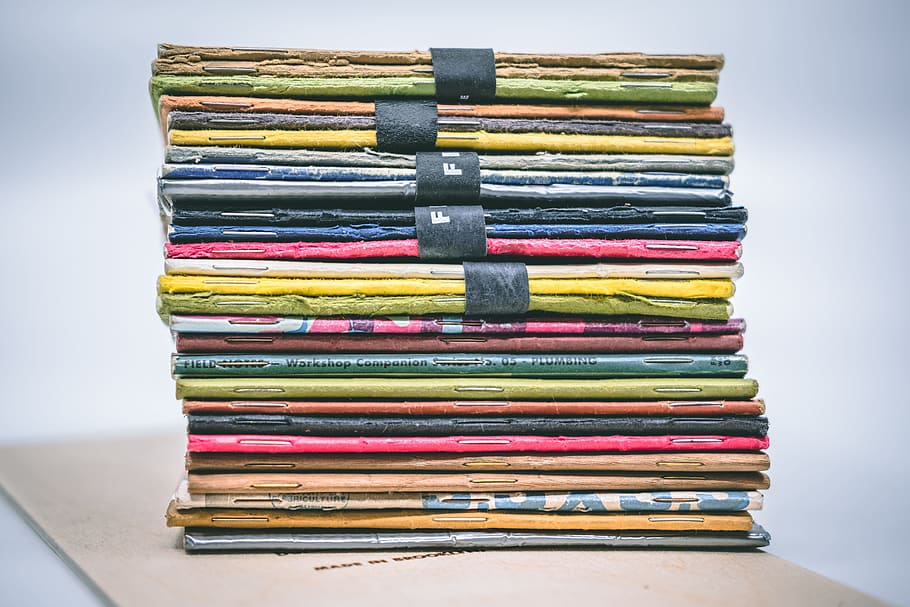 assorted-colored stacked books, pocket notebook, fieldnote, large group of objects HD wallpaper