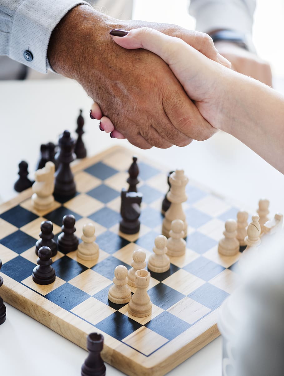 Man and Woman Shaking Hands over a Game of Chess, board game