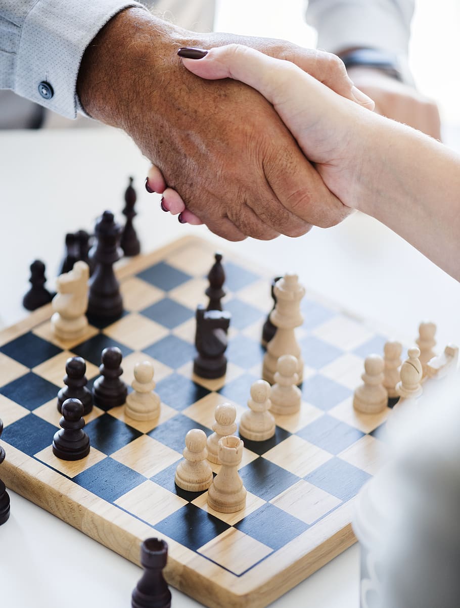 Download A Person Is Playing Chess On A Board Wallpaper