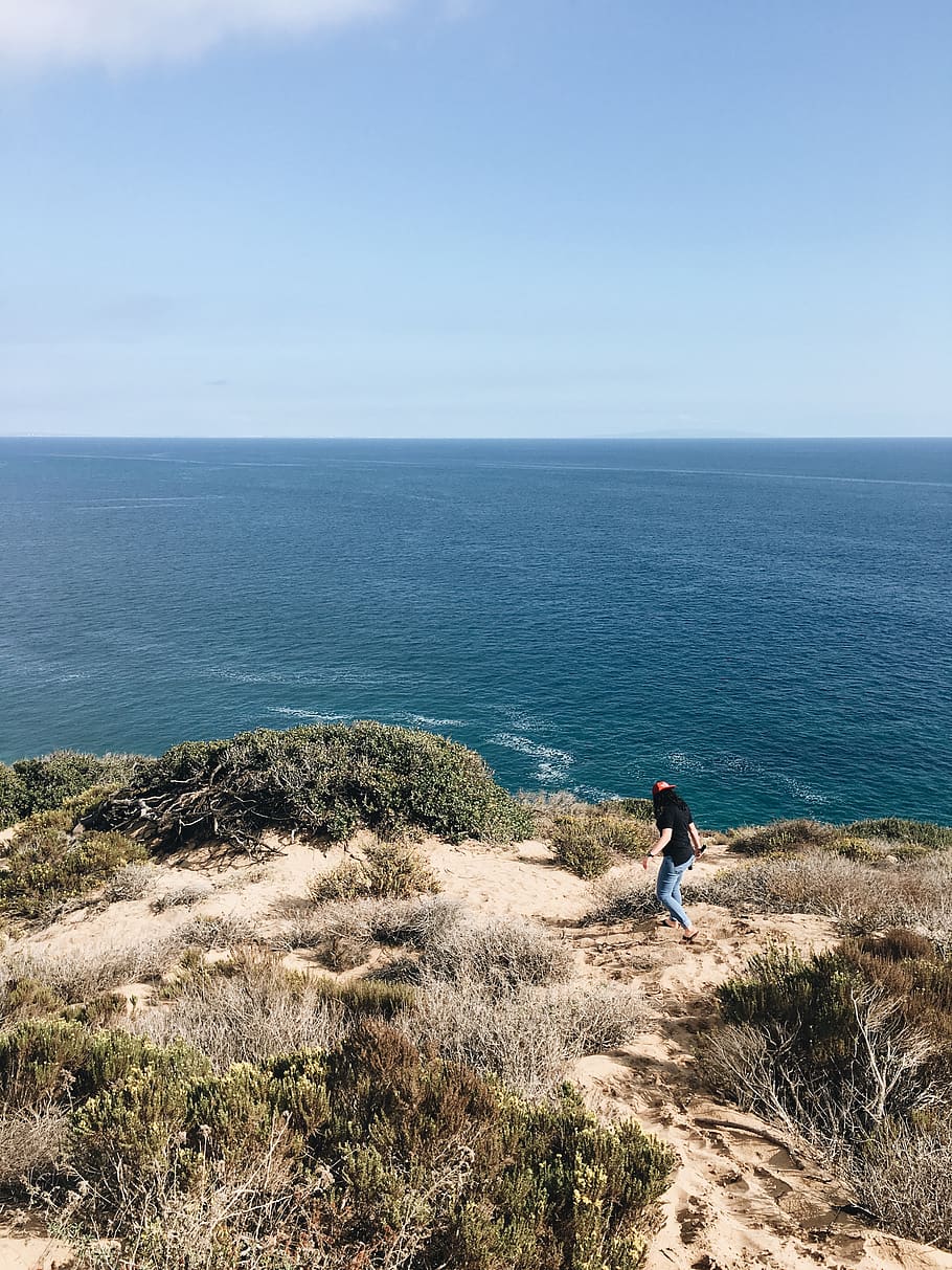 Woman Standing Beside Cliff Near Ocean, daylight, grass, horizon HD wallpaper
