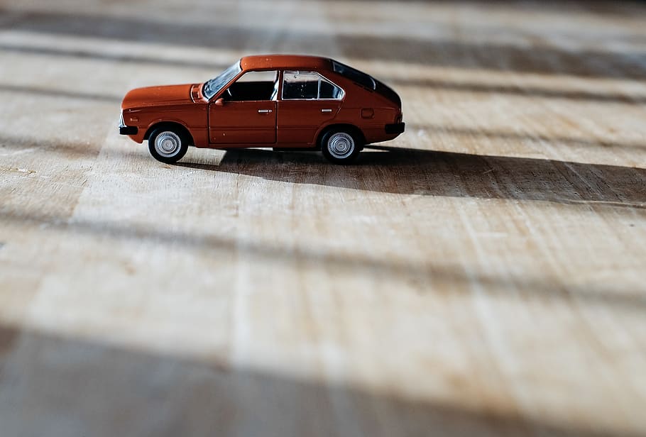 red 5-door hatchback vehicle scale model on top of brown surface, HD wallpaper