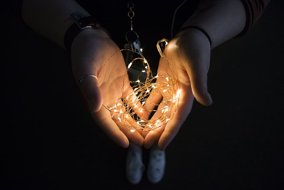 yellow string light on human hand, person, people, seguin, united states HD wallpaper