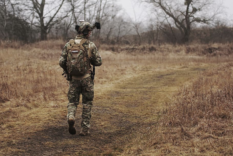Man Wearing Military Uniform and Walking through Woods, armed