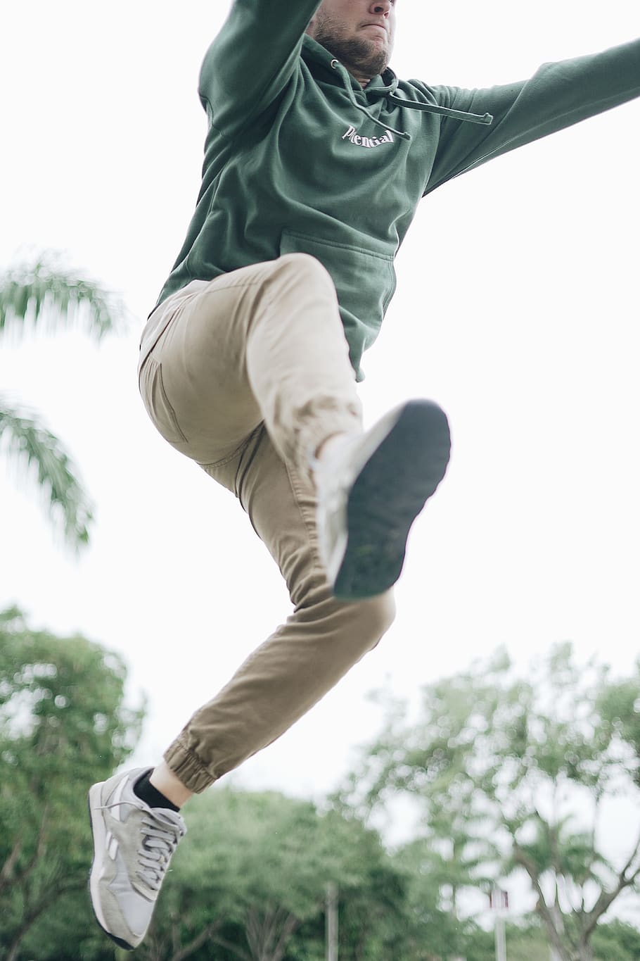 man jumping near tree, apparel, clothing, footwear, shoe, person HD wallpaper