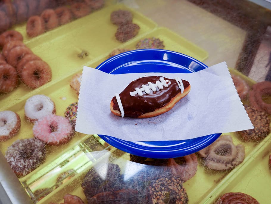 A football shaped donut sitting on a blue plate., bakery, breakfast, HD wallpaper