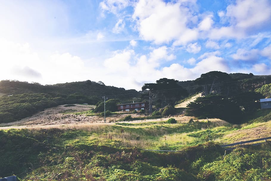 Brown Building Surrounded by Plants and Mountains, clouds, daylight HD wallpaper