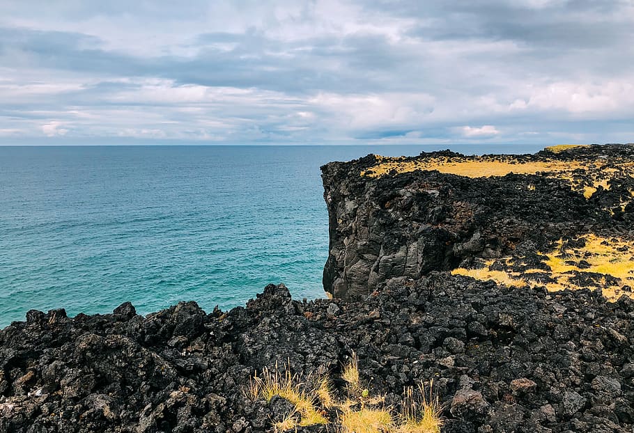 black rocks near body of water, promontory, cliff, outdoors, nature