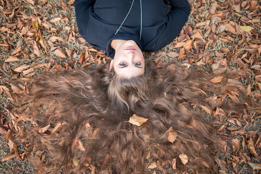 flay lay photography of brown long-haired woman wearing black crew-neck top laying on field with dry leaves, HD wallpaper