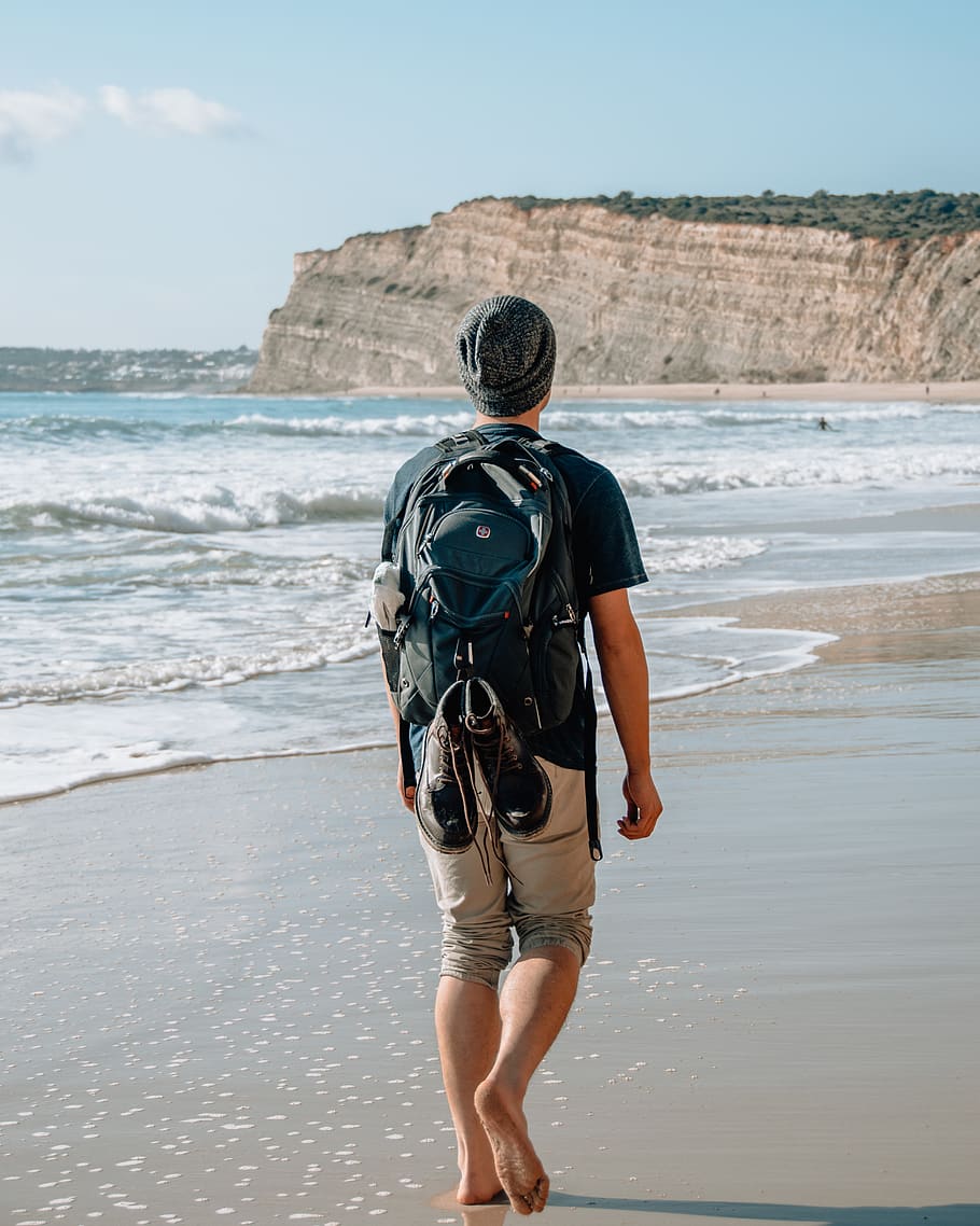 man walking on seashore near cliff, beach, rear view, water, land, HD wallpaper