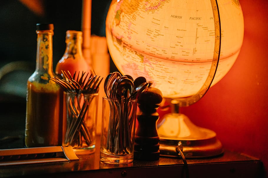 Lighted Desk Globe Beside Condiment Shaker and Flatware Set, bottles HD wallpaper