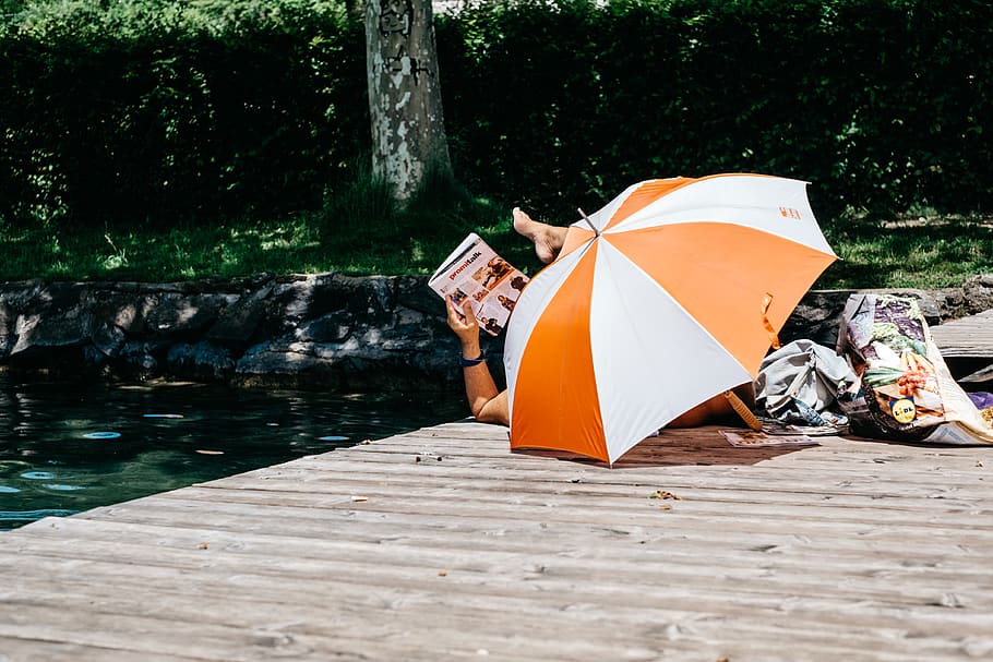 person lying on dock, water, tree, day, nature, orange color HD wallpaper