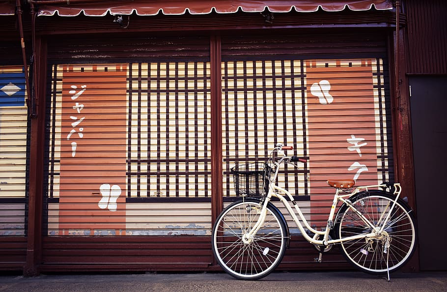 white beach bicycle beside brown and white painted house, bike