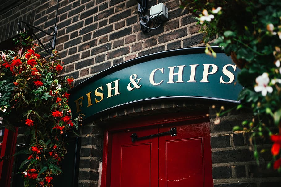 Fish and chips sign at a traditional restaurant entrance in the UK HD wallpaper