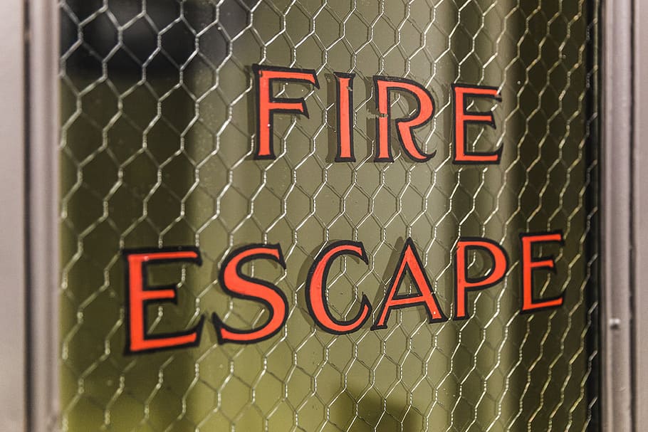 Close up of Fire Escape written on the glass pane of a door, utility