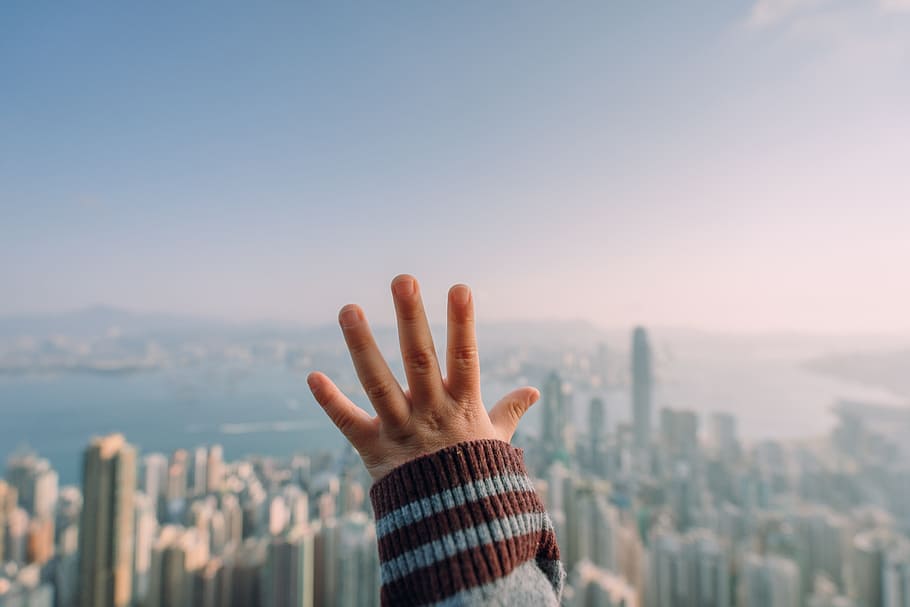 selective focus photo of person hand, building, cityscape, reach HD wallpaper
