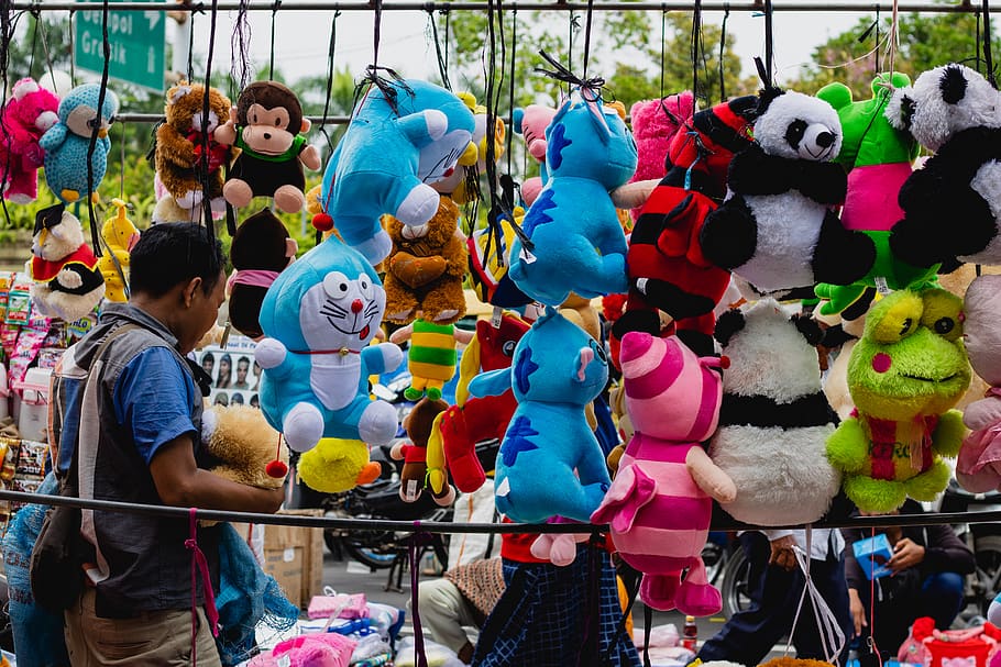 man in blue polo shirt standing in front of assorted-color of plush toy lot display, HD wallpaper