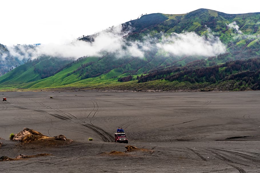 Person Riding Red Car on Vast Land Near Mountains, adventure HD wallpaper