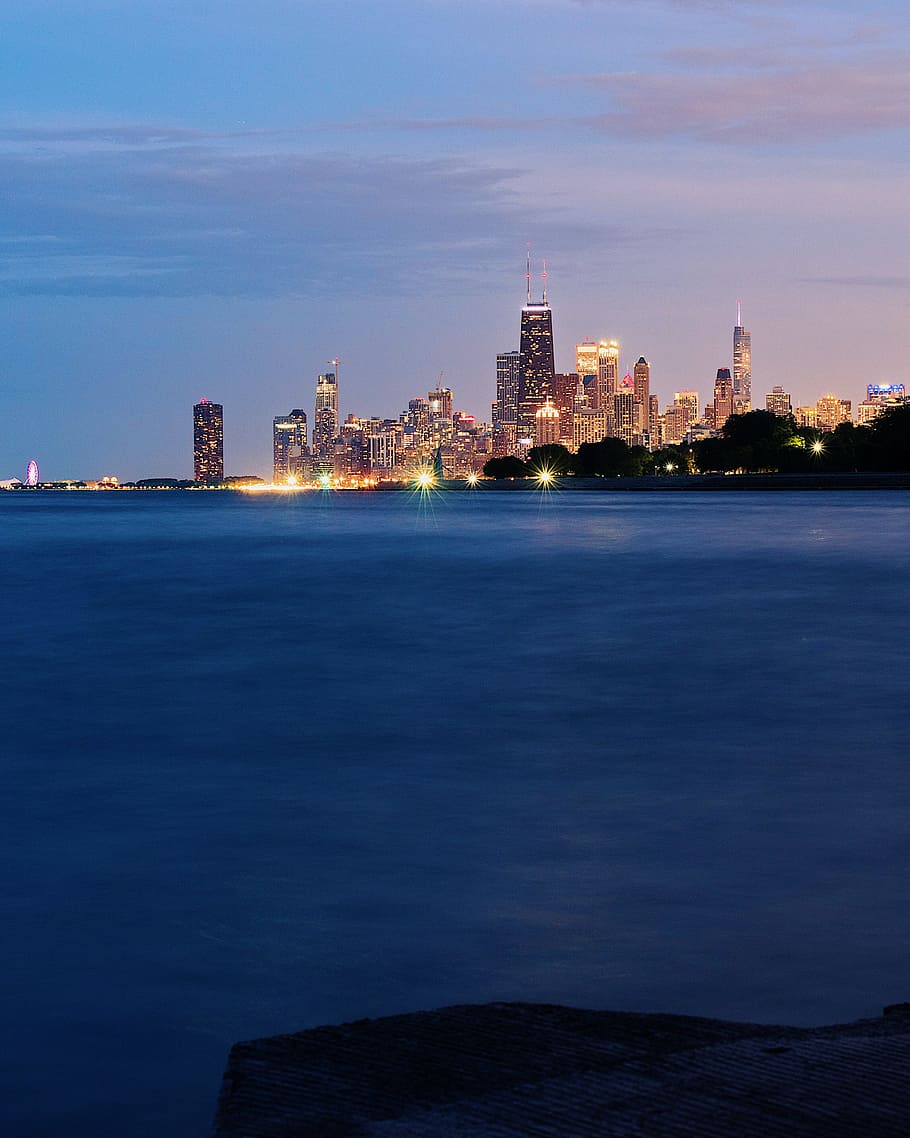 landscape photo of lighted buildings near body of water, evening HD wallpaper