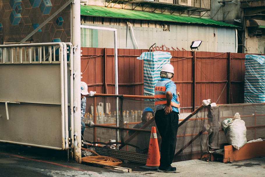 man standing beside traffic cone, human, person, apparel, helmet, HD wallpaper