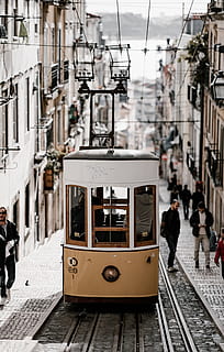 brown tram along buildings, street, cable, train, city, urban HD wallpaper