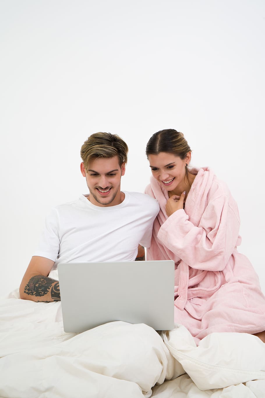 Man in White Crew-neck Shirt Sitting on Bed Beside Woman in Pink Bathrobe Looking at Laptop Computer, HD wallpaper