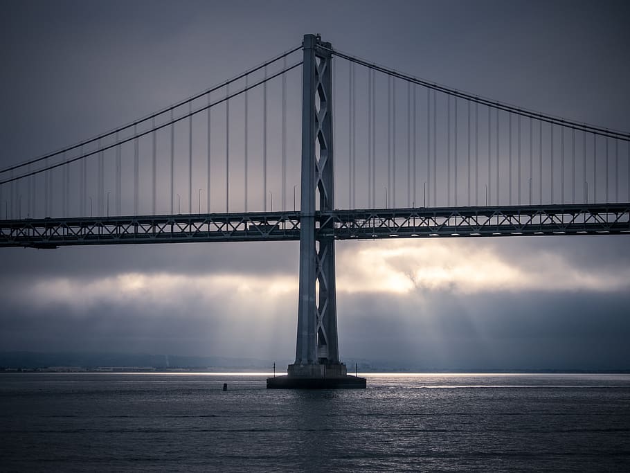 building, infrastructure, bridge, sea, ocean, water, dark, clouds HD wallpaper