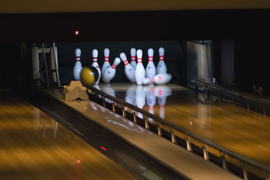 bowling balls hitting pins, leisure activities, no people, indoors
