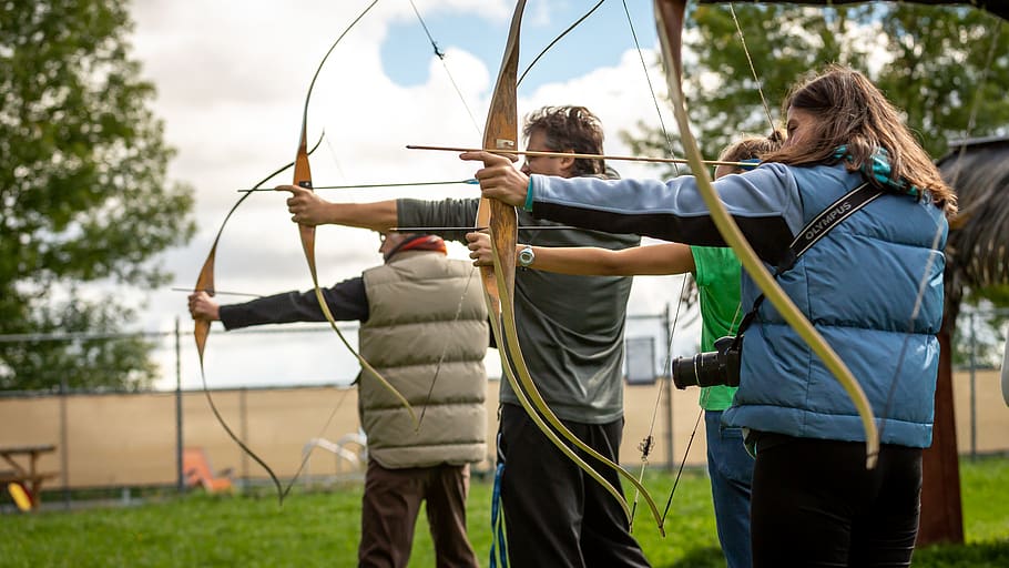 three person practicing using arrow, two people, grass, real people HD wallpaper