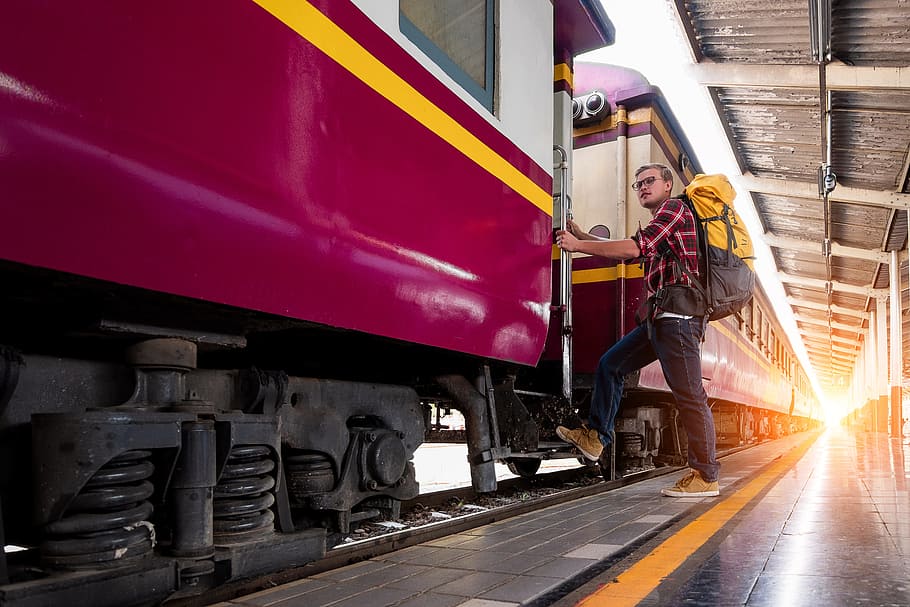 Man With Yellow and Black Backpack Standing Near Train, boarding HD wallpaper