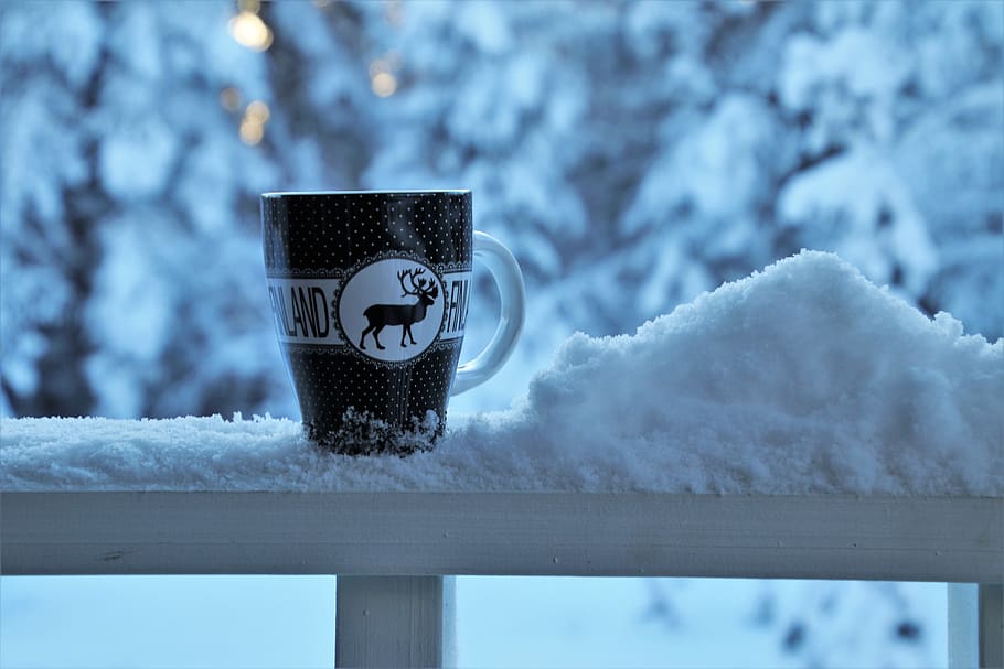 Hot Coffee cup on a frosty winter day window background