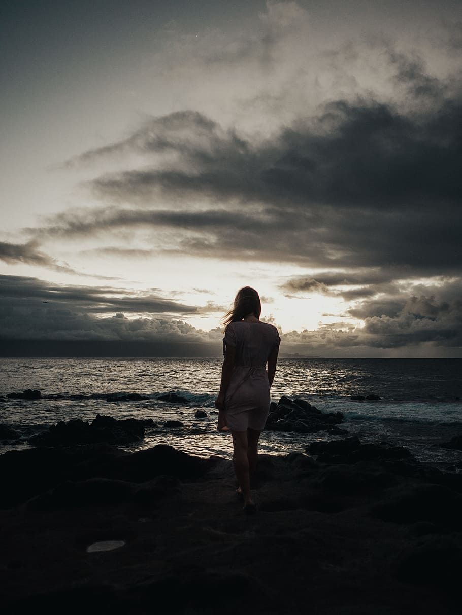 silhouette photography of woman standing near sea waves, female