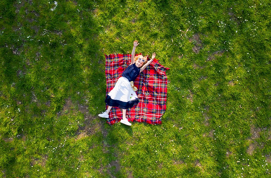 Girl Lying on Flannel Blanket with hands raised, aerial photography, HD wallpaper