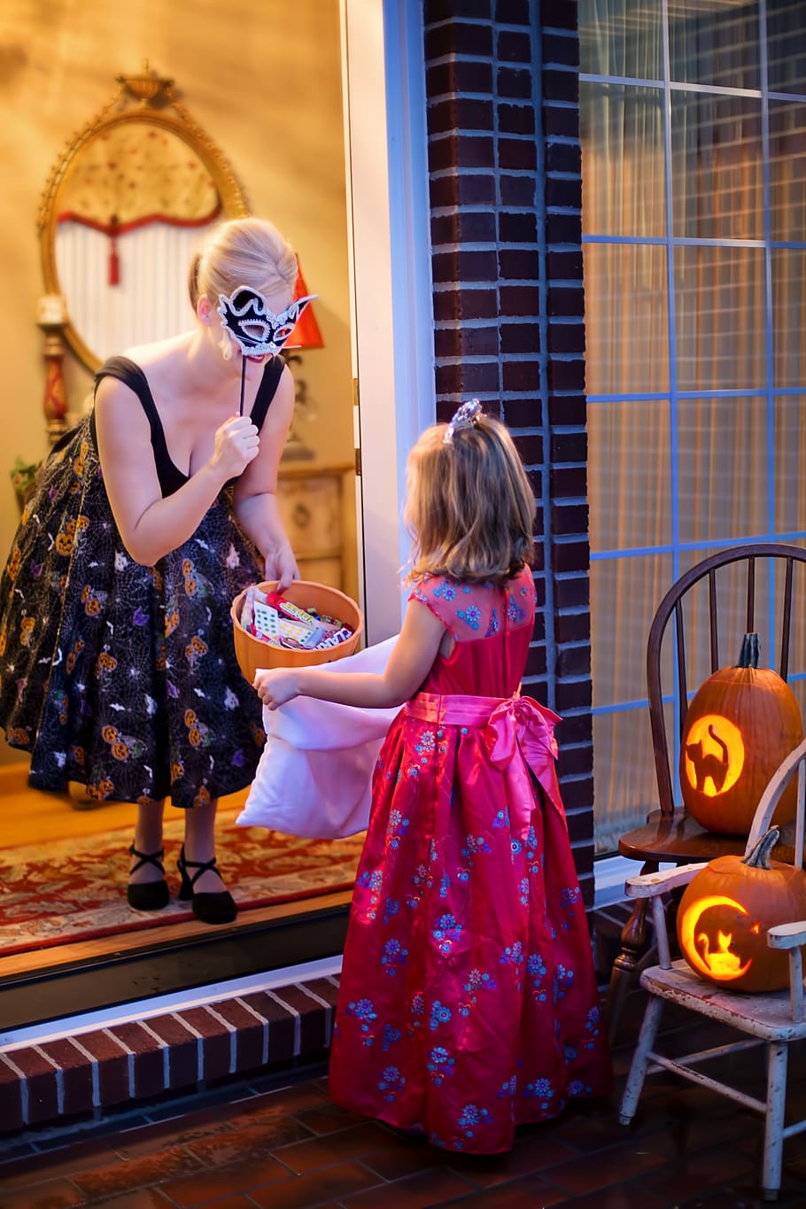 Woman Making Trick of Treat in Front of a Girl, adult, celebration