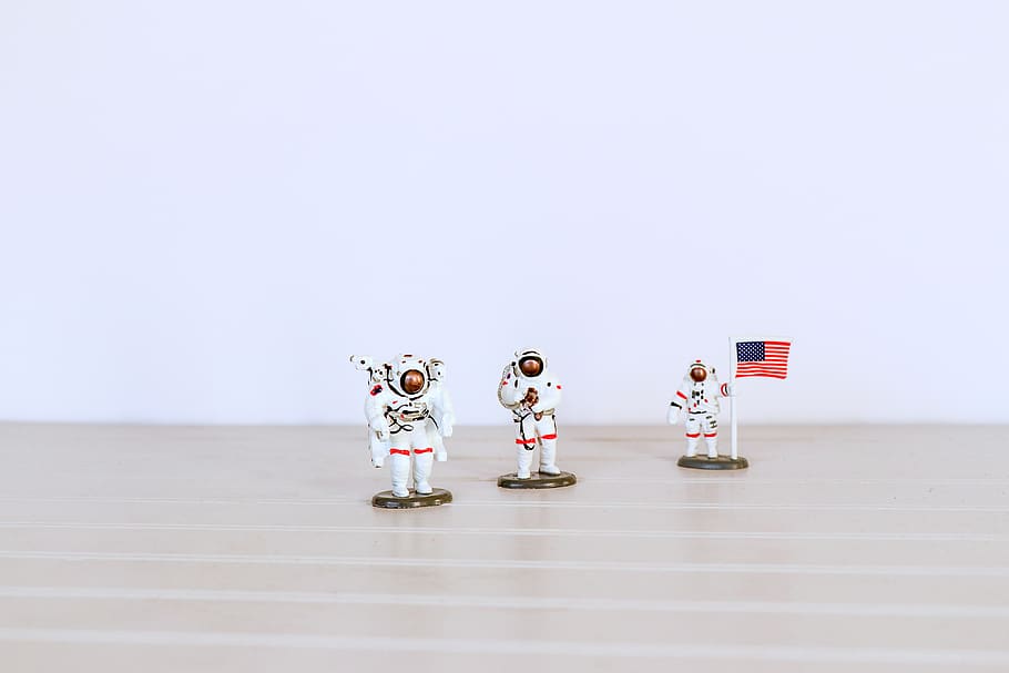 three astronaut figures on gray surface, indoors, human representation HD wallpaper