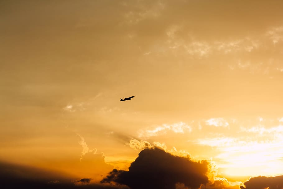 plane over black clouds in orange sky, art, color, minimal, sunset HD wallpaper