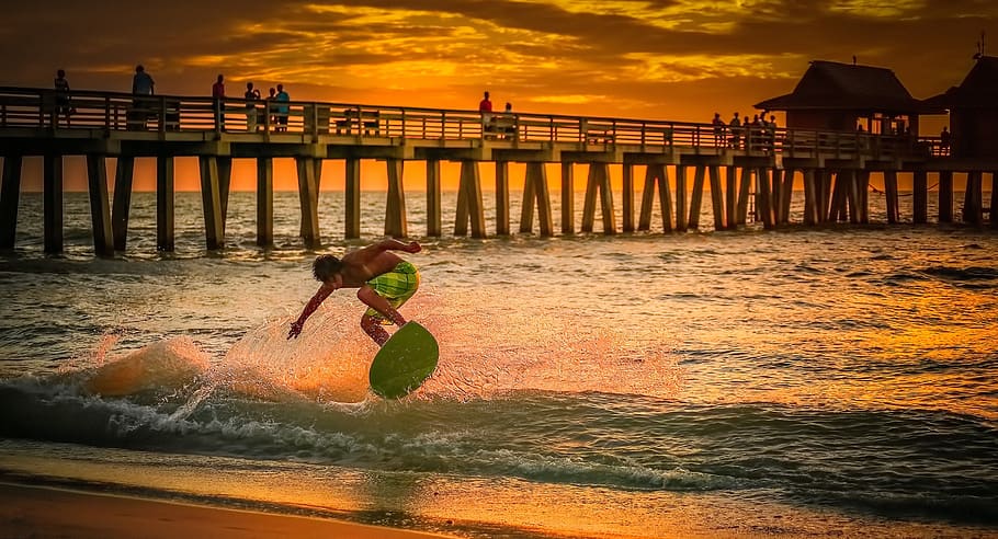 Man Wearing Green Shorts Surfing during Golden Hour, beach, clouds HD wallpaper