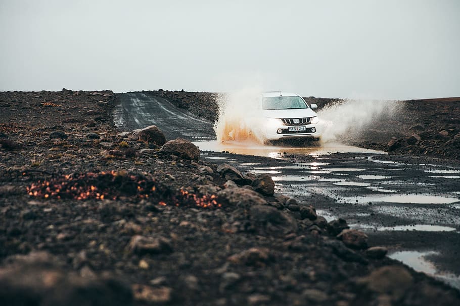 White pick-up truck puddle splashing on a muddy road, drive, driving