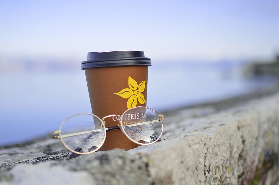 gold-colored framed eyeglasses beside plastic disposable cup, HD wallpaper