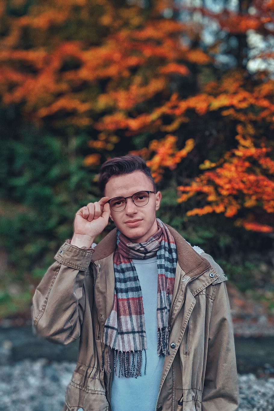 man wearing brown jacket over blue shirt standing near the stream HD wallpaper
