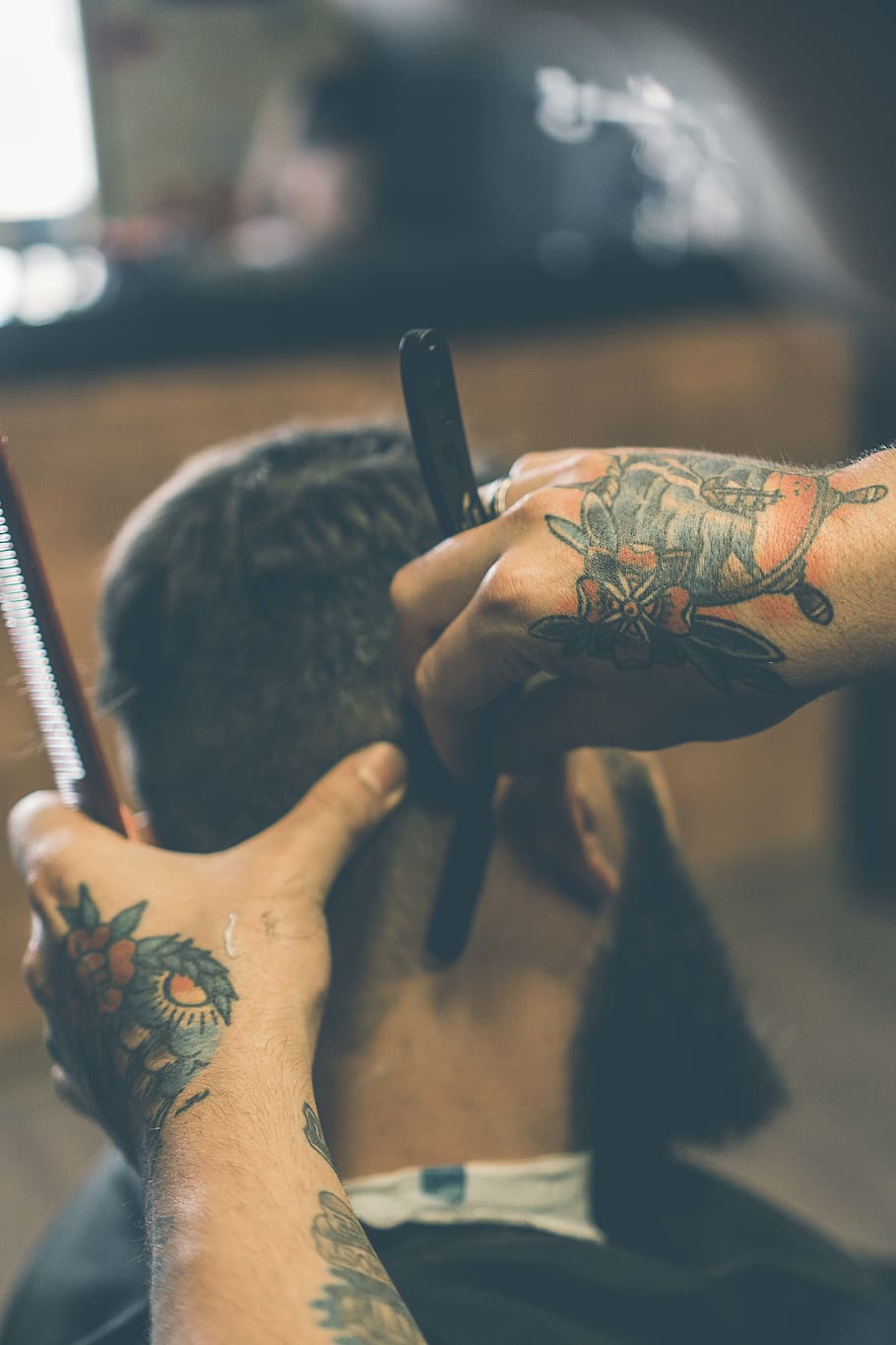 Beard correction. Barber in black gloves with tattoo on his arm applying  shaving foam on the face of young man sitting in a barbershop chair.  Grooming and shaving Stock Photo | Adobe