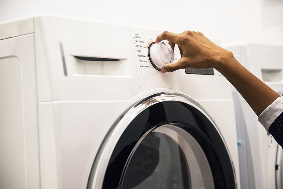 Person Adjusting Control on Front-load Clothes Washer, close-up