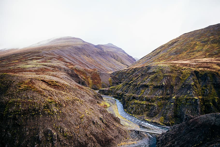 A fresh water stream through the rocky hills covered with clouds HD wallpaper