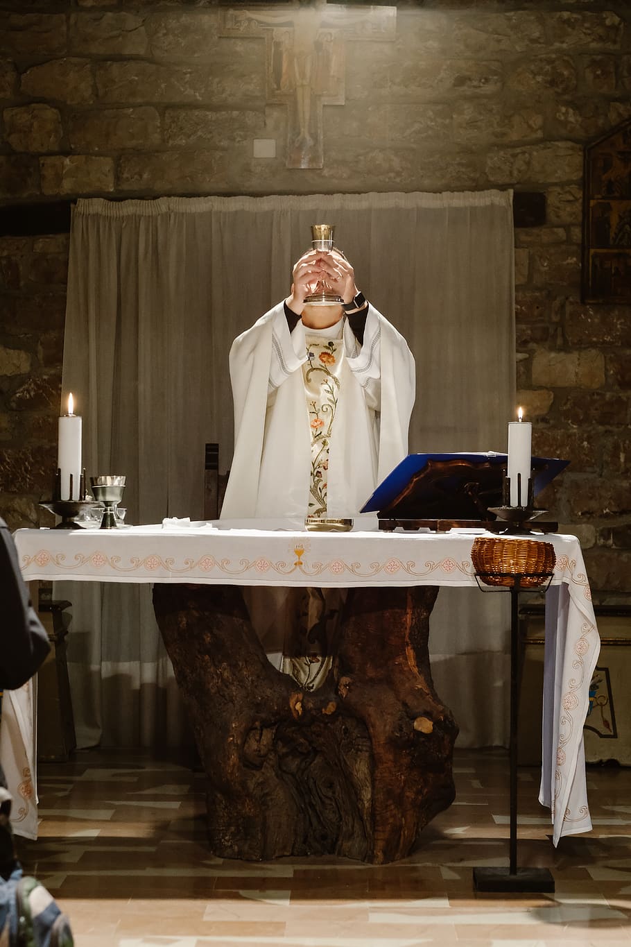 priest lifting goblet while standing beside table, indoors, front view HD wallpaper