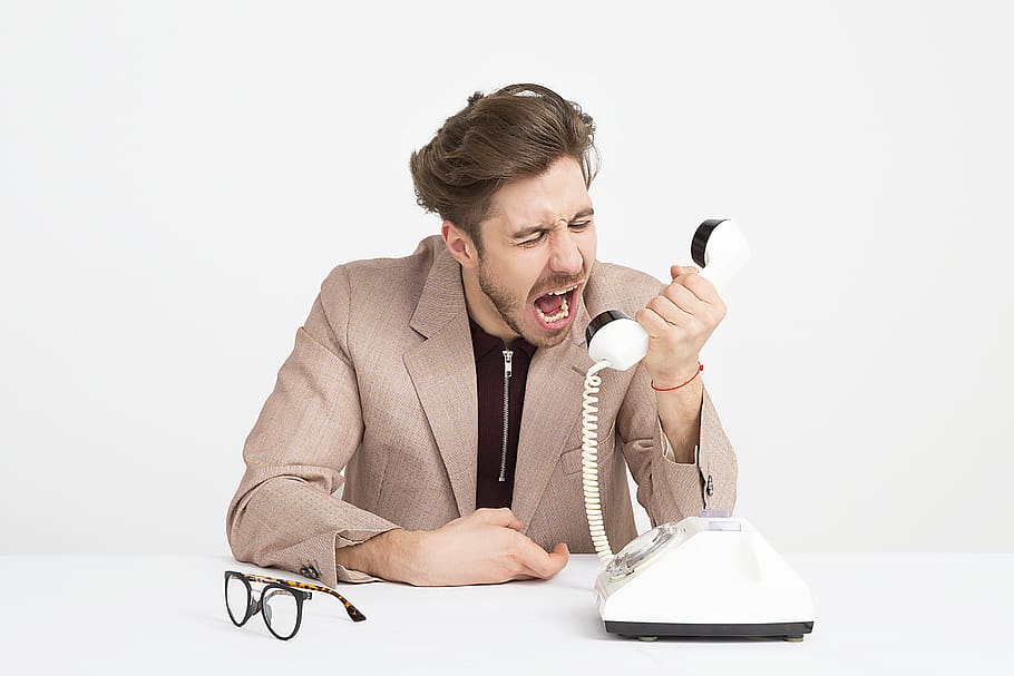 Man Wearing Brown Suit Jacket Mocking on White Telephone, adult